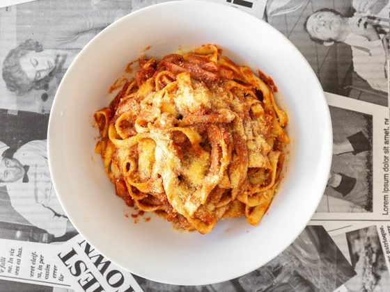Matricana fettuccine in tomato sauce with grated parmesan, in a white bowl