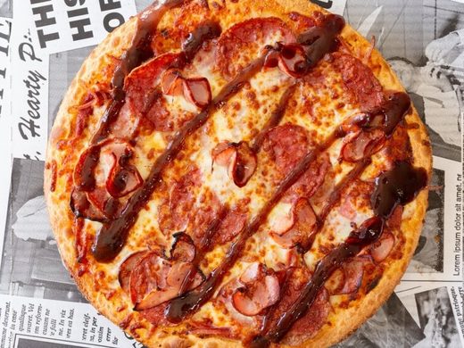 Meat Lovers pizza with ham, bacon, salami and cabanossi under a BBQ sauce drizzle